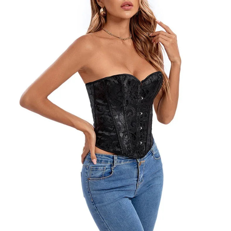 Kobieta w czarnym gorsetowym topie bez ramiączek i niebieskich jeansach na białym tle