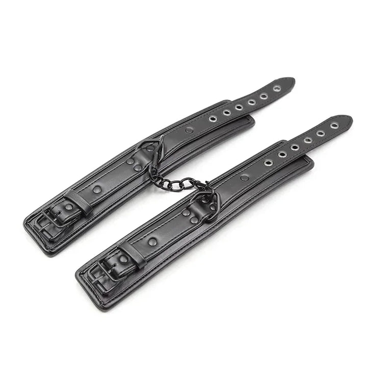 Czarne skórzane kajdanki na nadgarstki z metalowym łańcuszkiem i regulacją zapinane na klamry