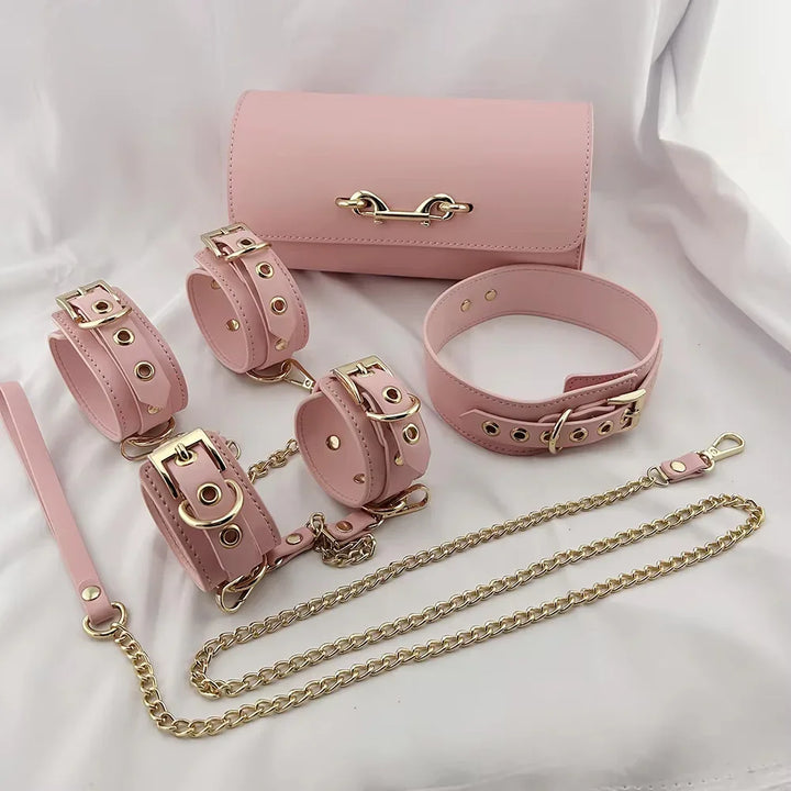 Różowy zestaw akcesoriów ze skóry i złotych łańcuszków na białym tle