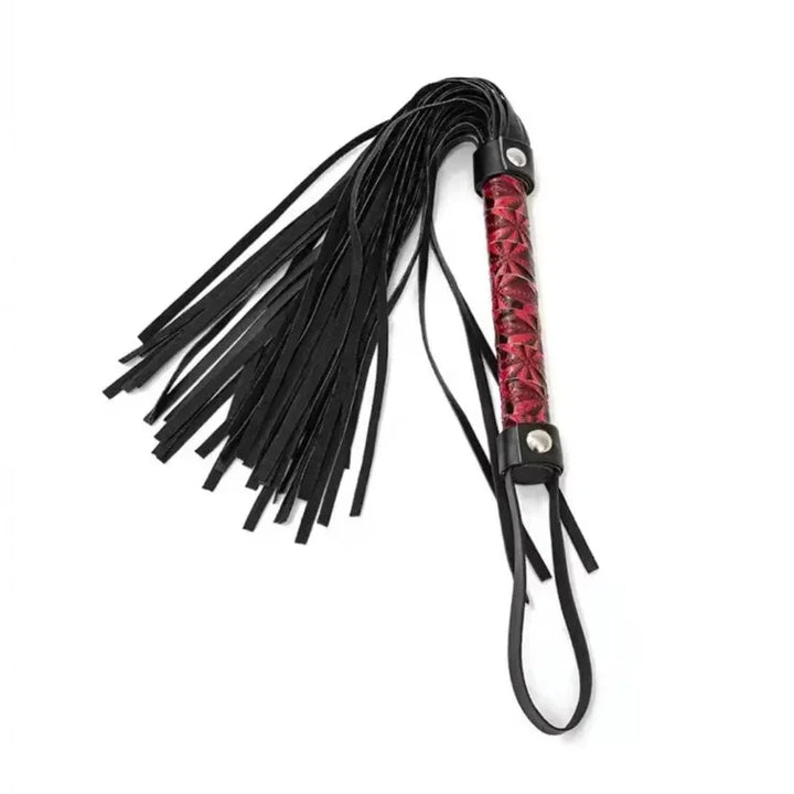 Skórzany pejcz z czarnymi frędzlami i czerwonym oplecionym uchwytem na białym tle